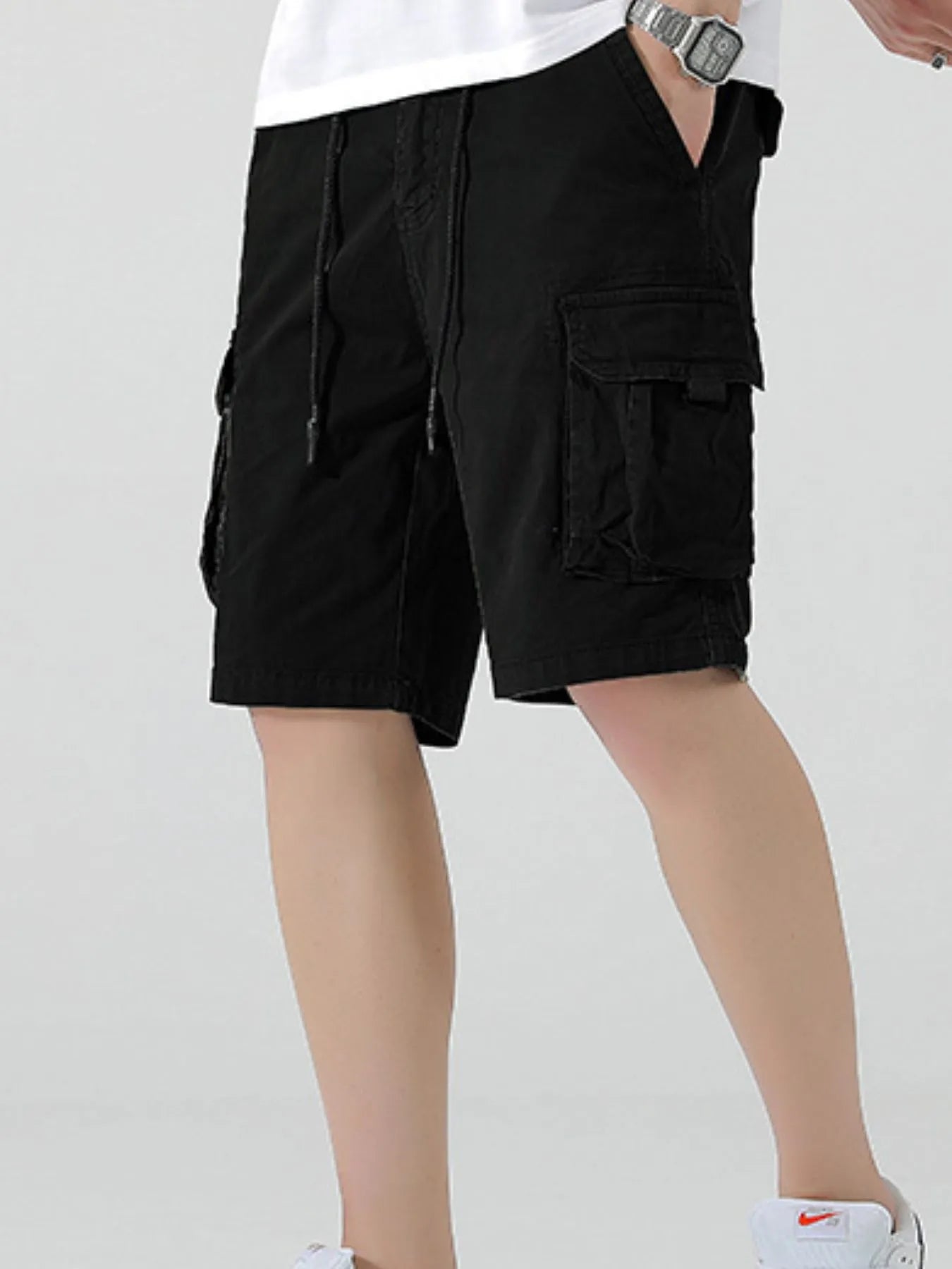 Black drawstring cargo shorts with pleated front and side cargo flap pockets