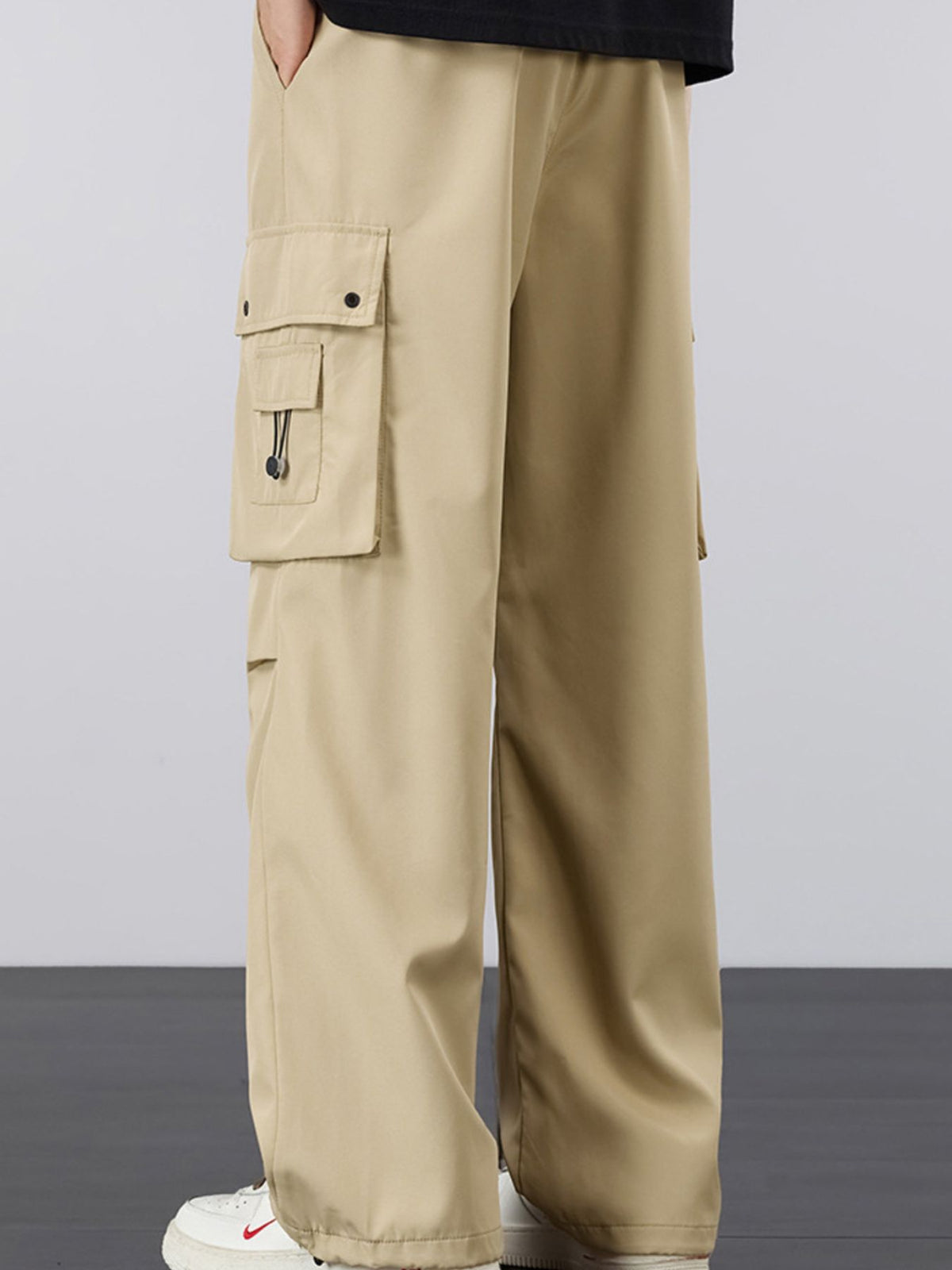 Khaki loose-fit cargo pants with drawstring waist and large flap cargo pocket