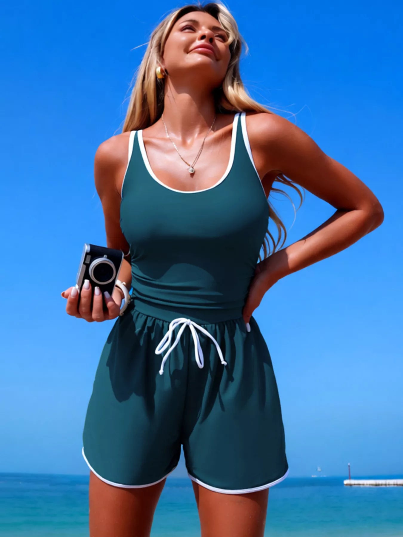 One-piece swimsuit in teal with white contrast trim, scoop neck, drawstring waist, pockets