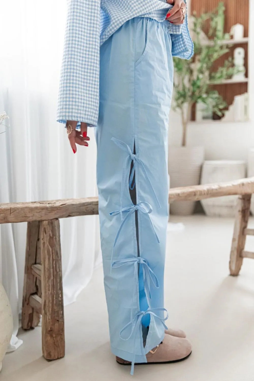 Light blue wide-leg pants with ruched side ties and long pocket drape