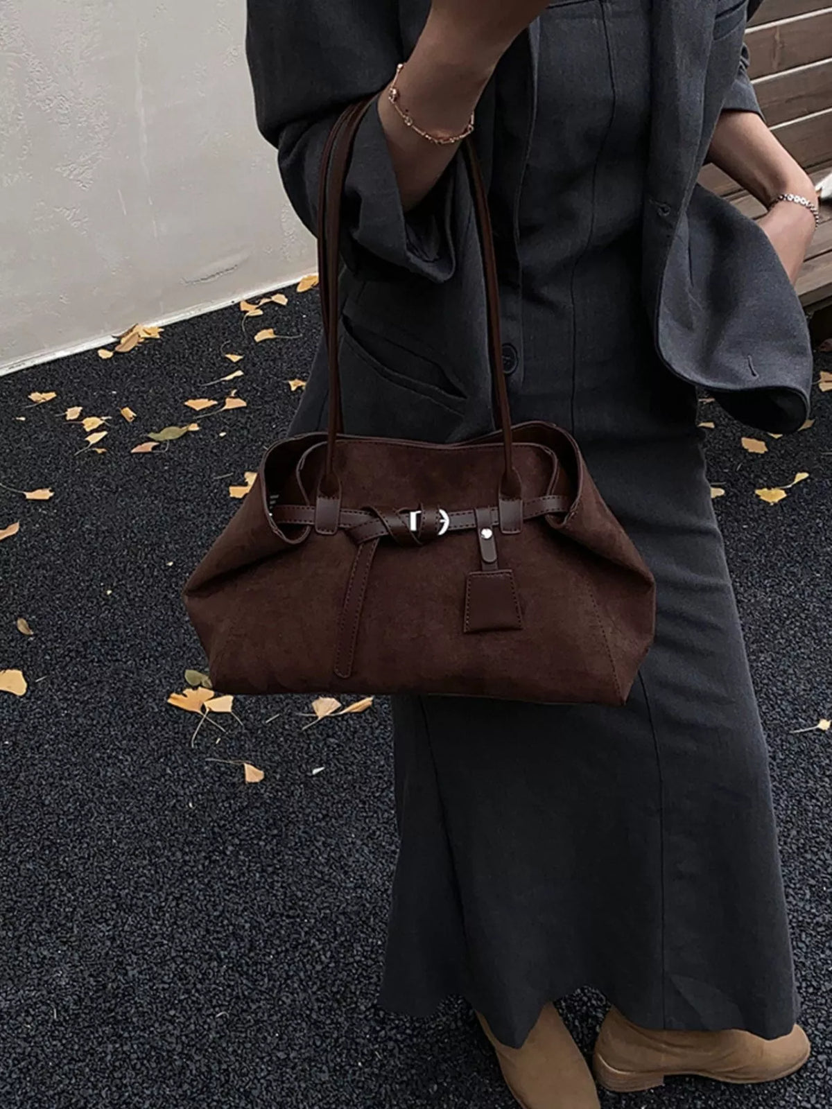 Dark brown suede buckle shoulder bag with adjustable crossbody strap and front patch