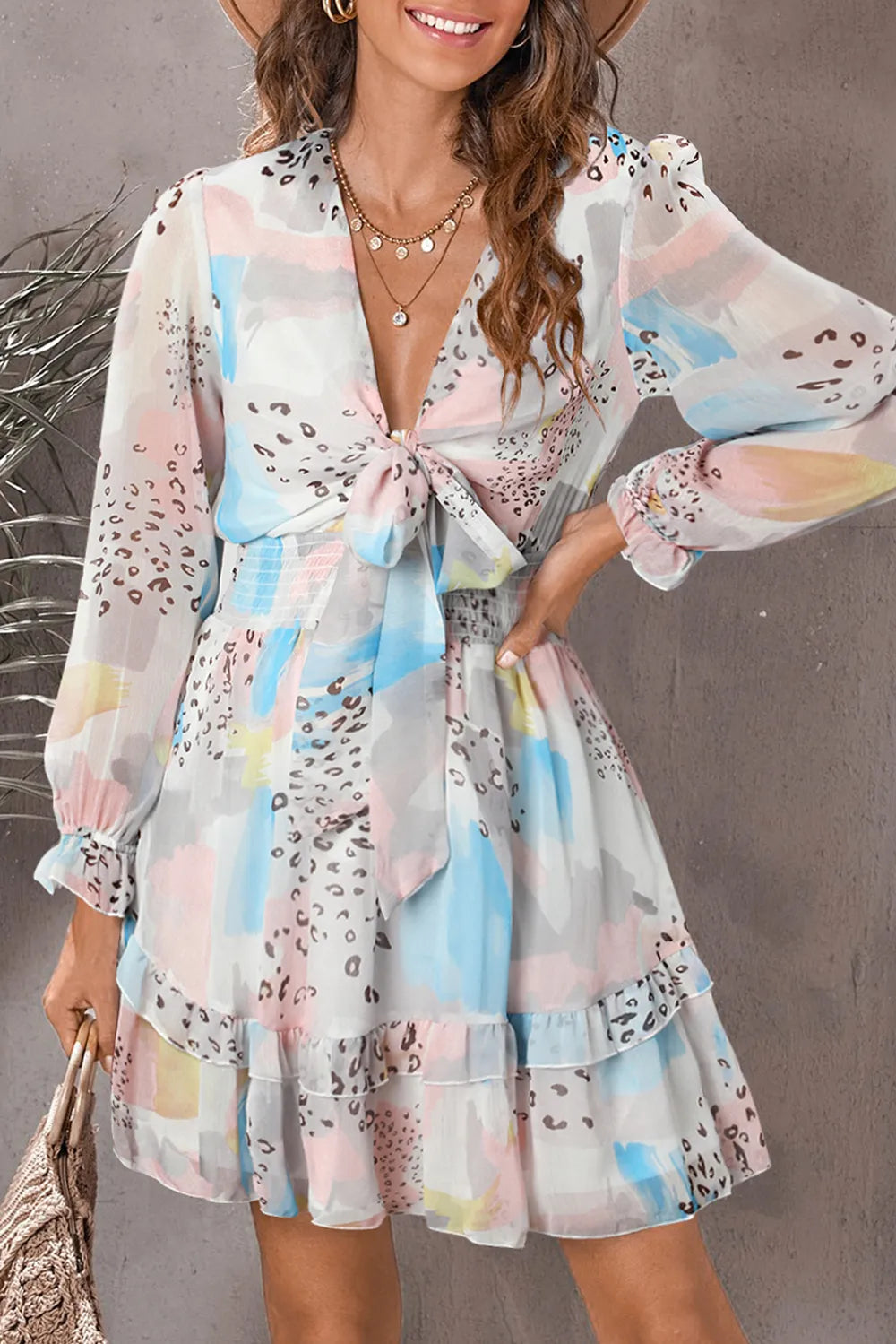 Printed flounce-sleeve mini dress in pastel abstract print with front tie and ruffled hem.