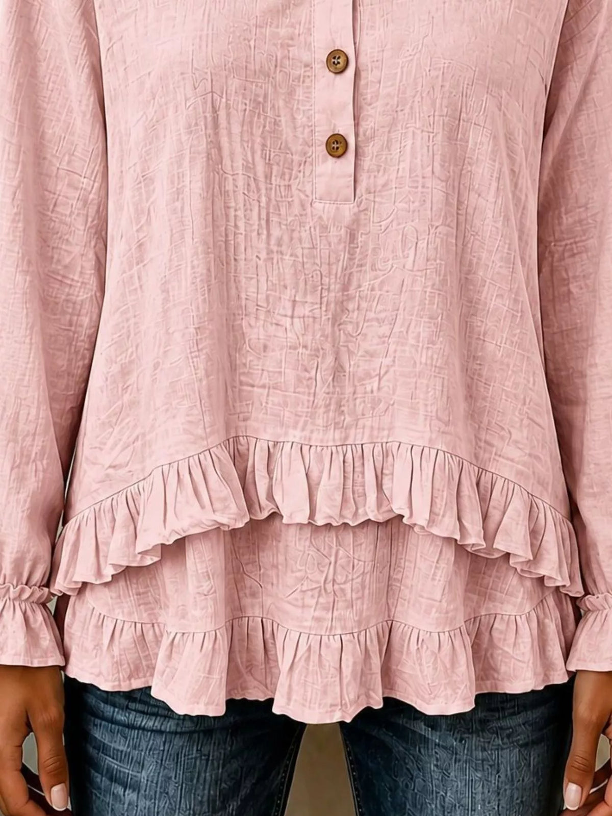 Pink long-sleeve blouse with layered ruffled hem and button placket
