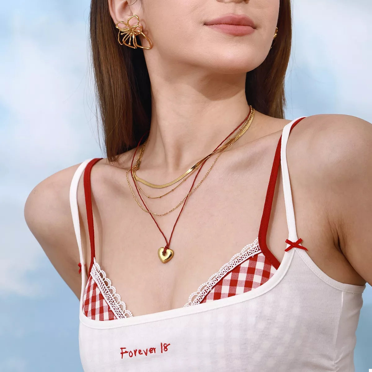 Four-layered heart necklace with gold chains and red cord, small heart pendant.