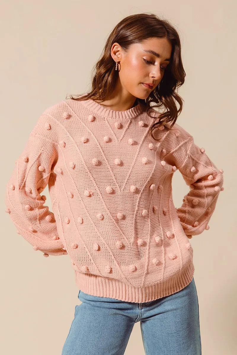 Blush pom-pom knit crewneck sweater with long sleeves and ribbed neckline