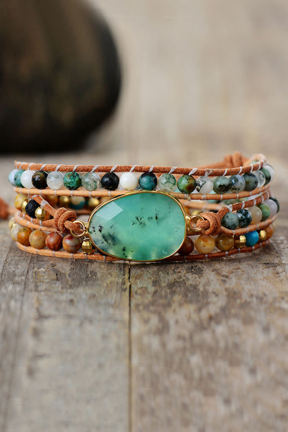 Layered beaded bracelet with turquoise oval centerpiece and braided leather strands