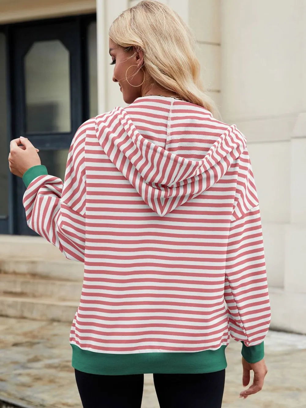 Pink-and-white striped zip-up hoodie with hood and drawstring, long sleeves.