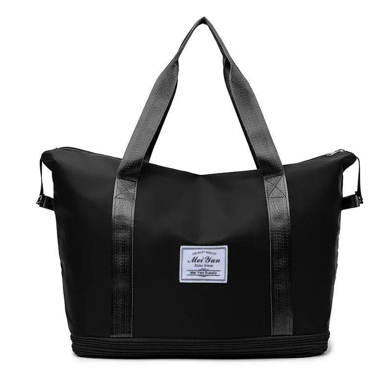 Black large duffle bag with two top handles, side straps, and front logo patch