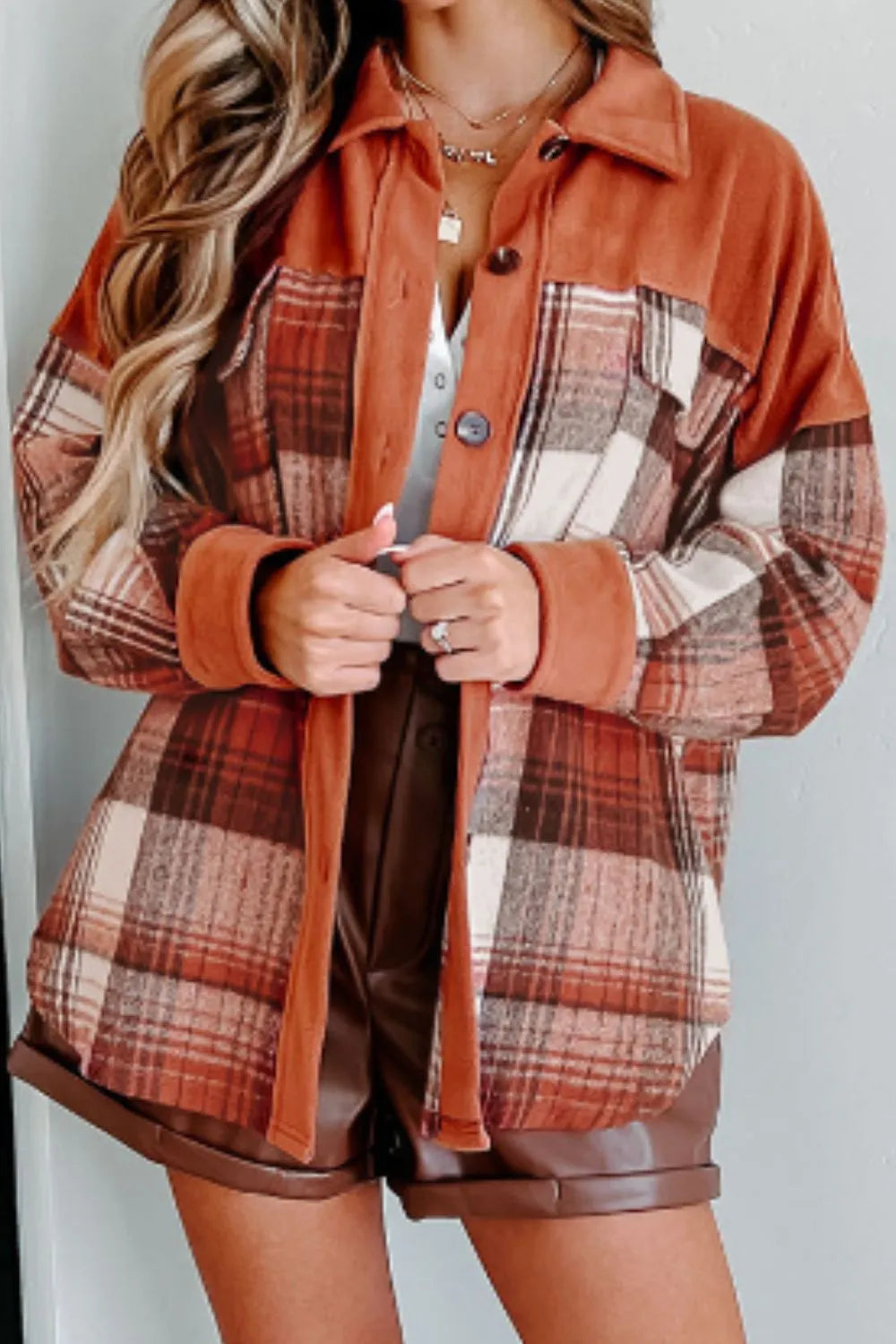 Plaid button-up long sleeve jacket in rust orange with chest pockets and dark buttons