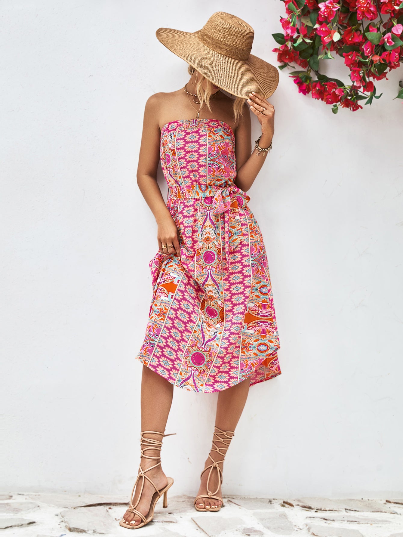 Hot pink strapless tie-belt dress with colorful patterned print, fitted bodice, midi