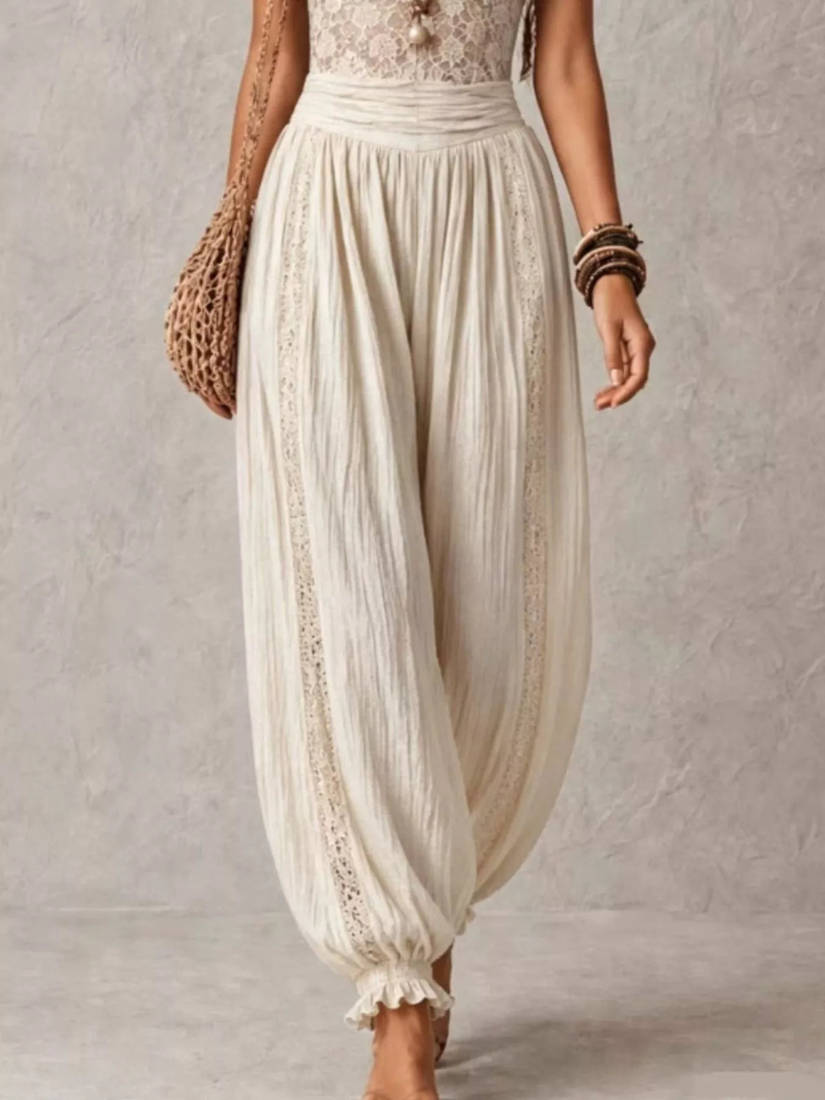 Cream lace corset jumpsuit with relaxed harem trousers and gathered ankle cuffs