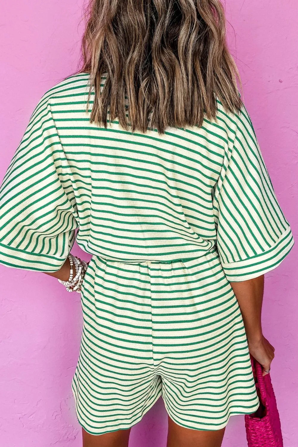 Green and white striped half-sleeve romper, back view, with tied waist detail