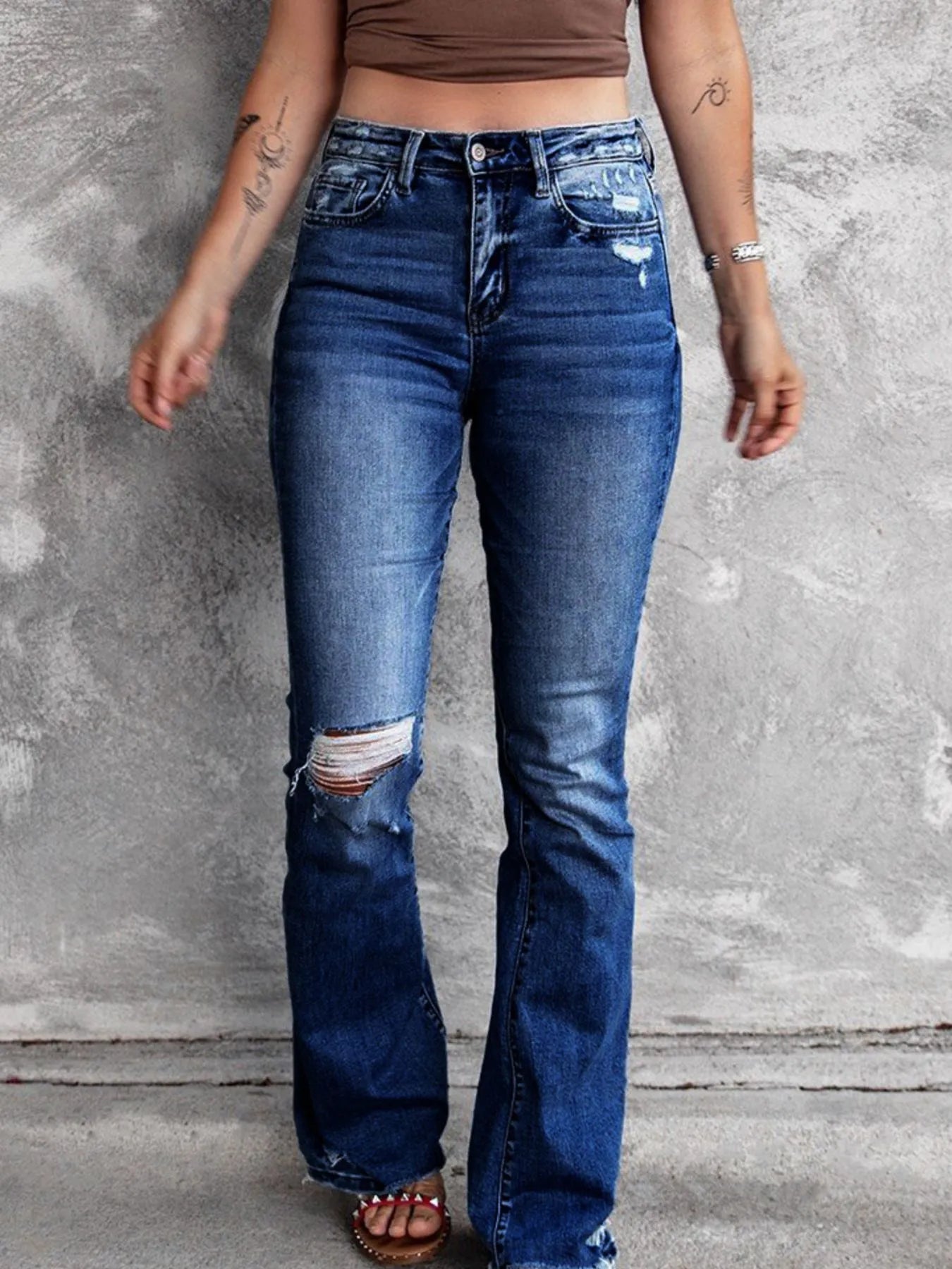 Medium blue distressed flare jeans with thigh rips and frayed hem details