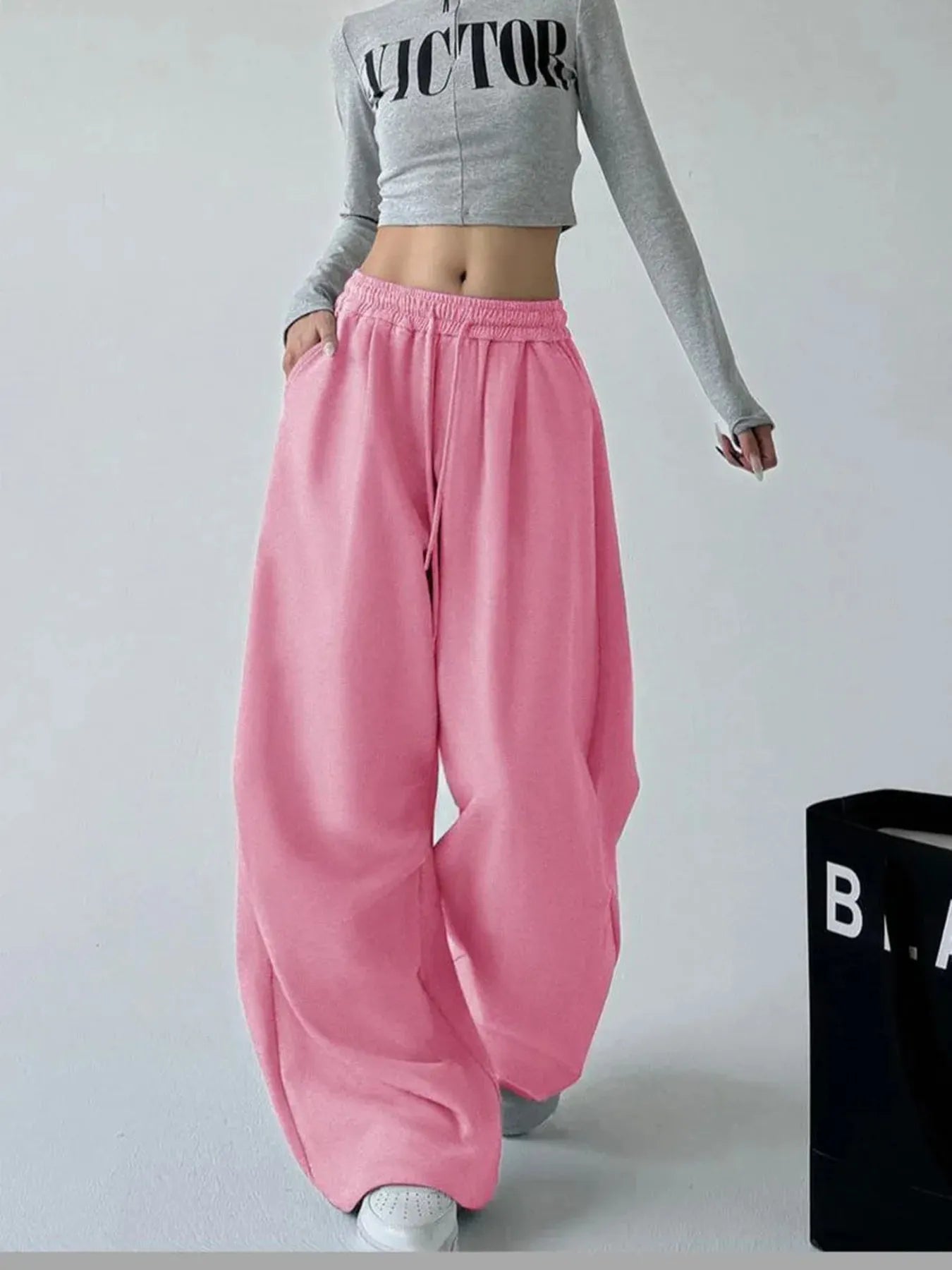 Pink oversized wide-leg drawstring pants with elastic waistband and side pockets