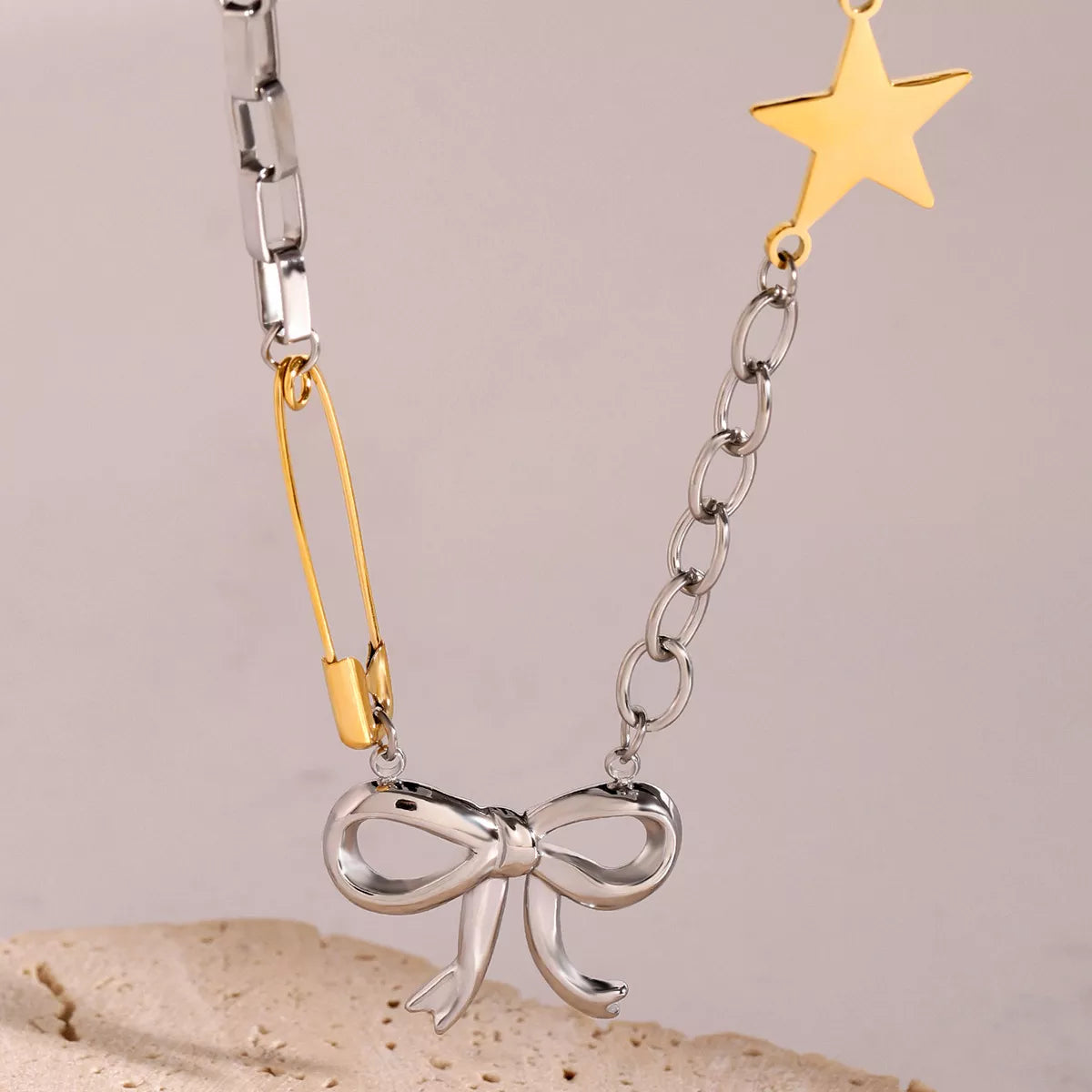 Two-tone star bow necklace: silver chain with dangling gold star and ribbon bow charm