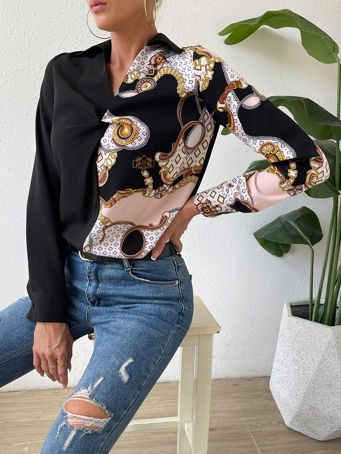 Black twist-front collared blouse with ornate patterned wrap front and long sleeves