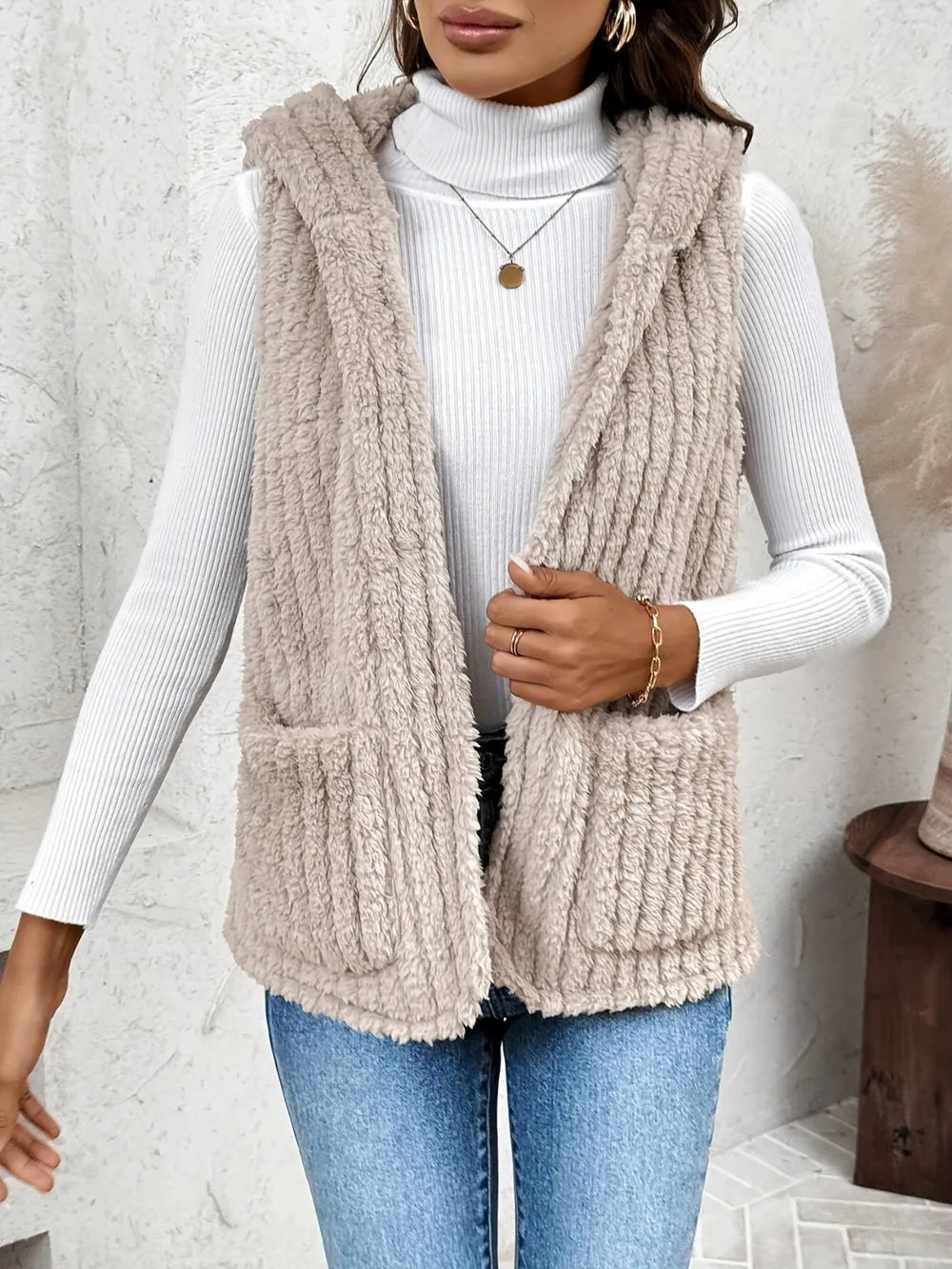 Fuzzy hooded vest with hood and front pockets, dusty beige textured fabric