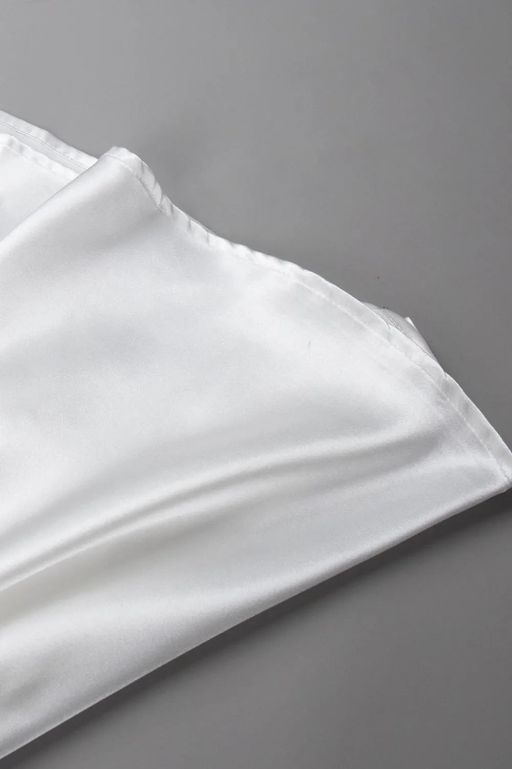 White satin skirt close-up with elastic waistband and smooth draped fabric