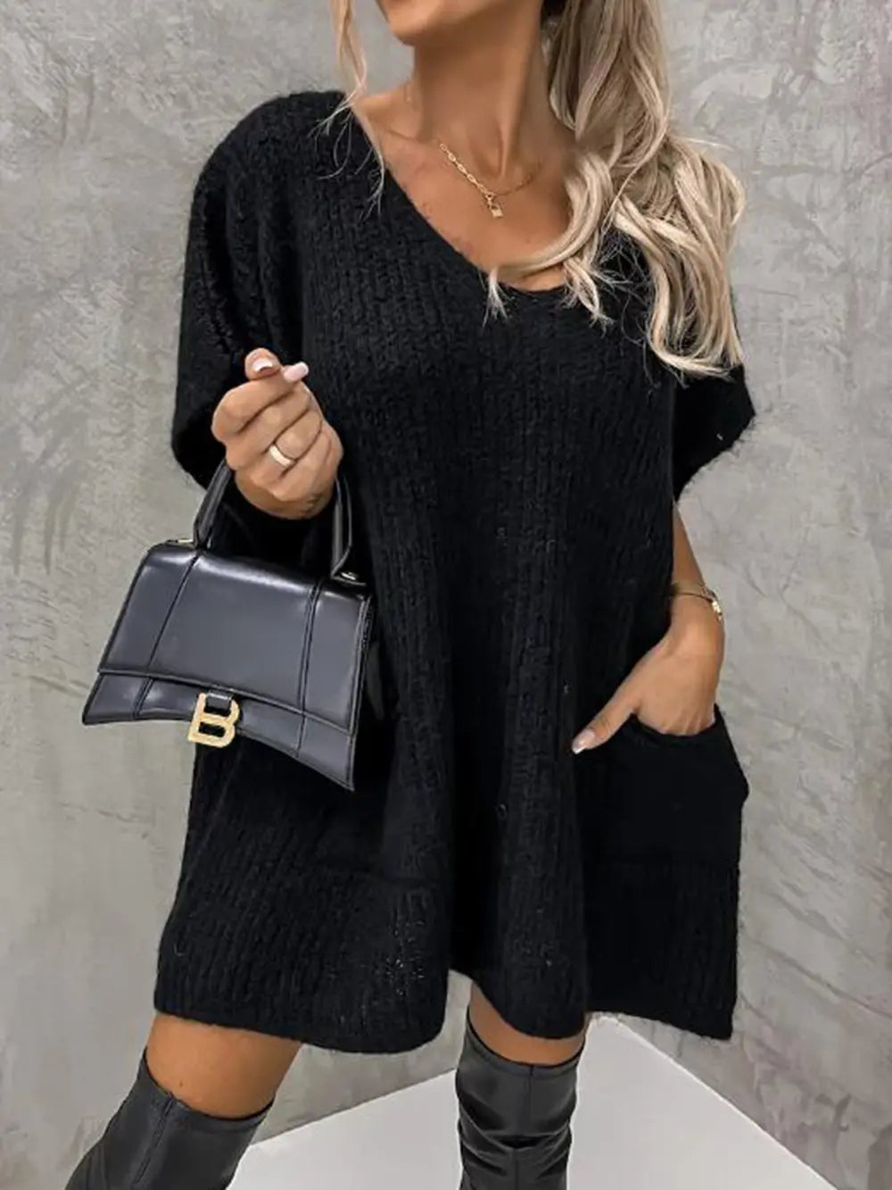 Black short-sleeve knit sweater with V-neck, relaxed fit and soft texture.