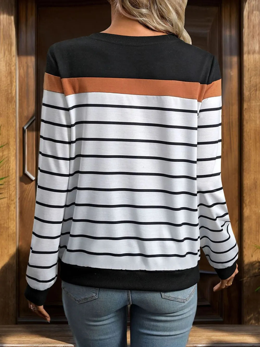 Back view of black and white striped crewneck long-sleeve sweatshirt with rust-brown band