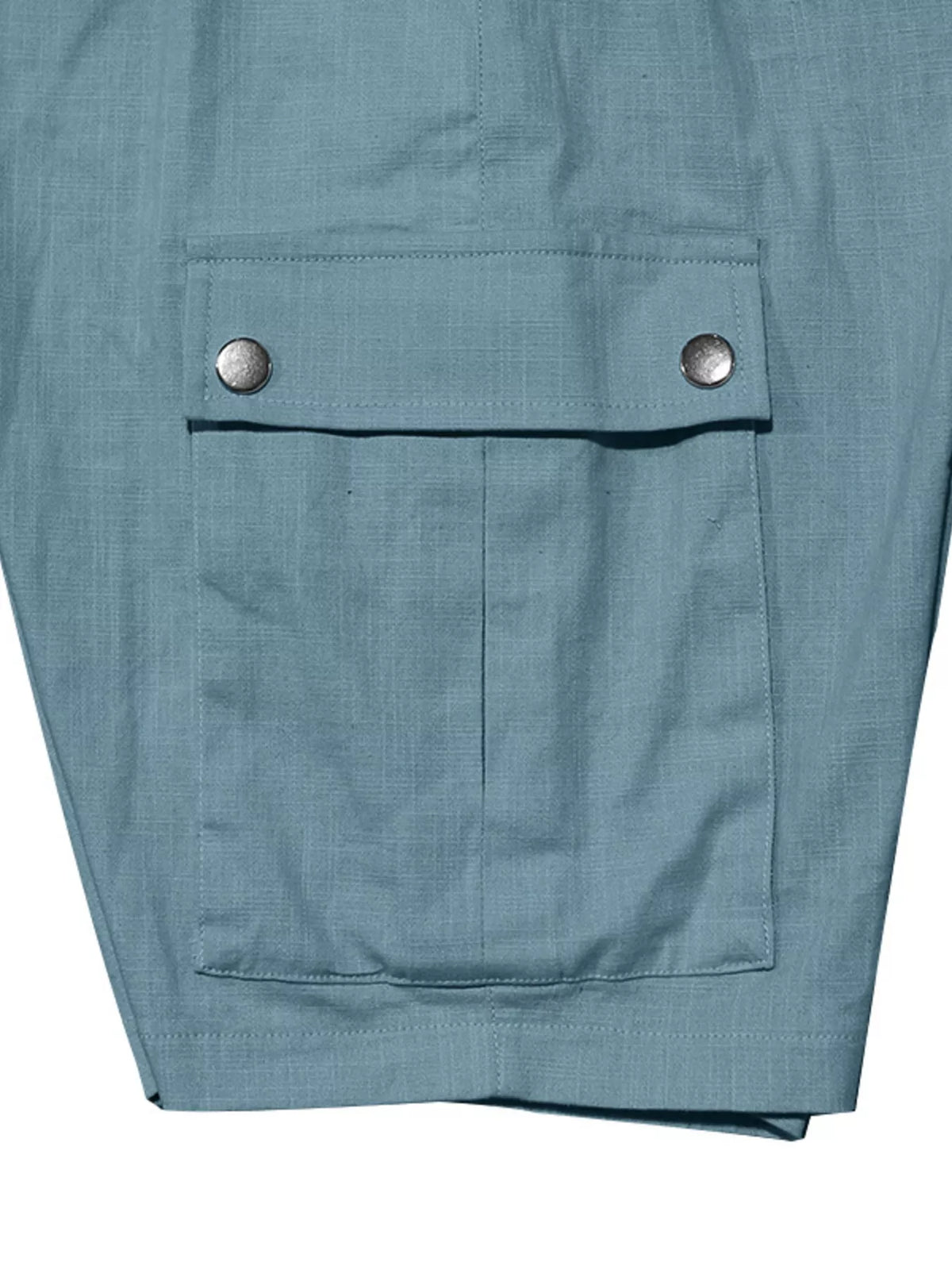 Men’s light blue cargo shorts close-up of front pocket flap with two button details.