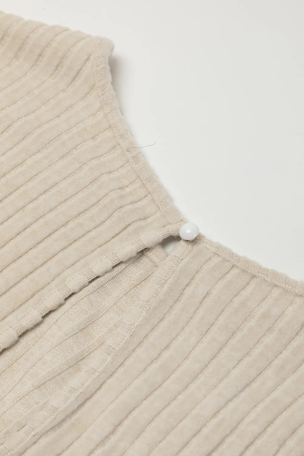 Beige ribbed knit jumpsuit shoulder button and neckline edge detail