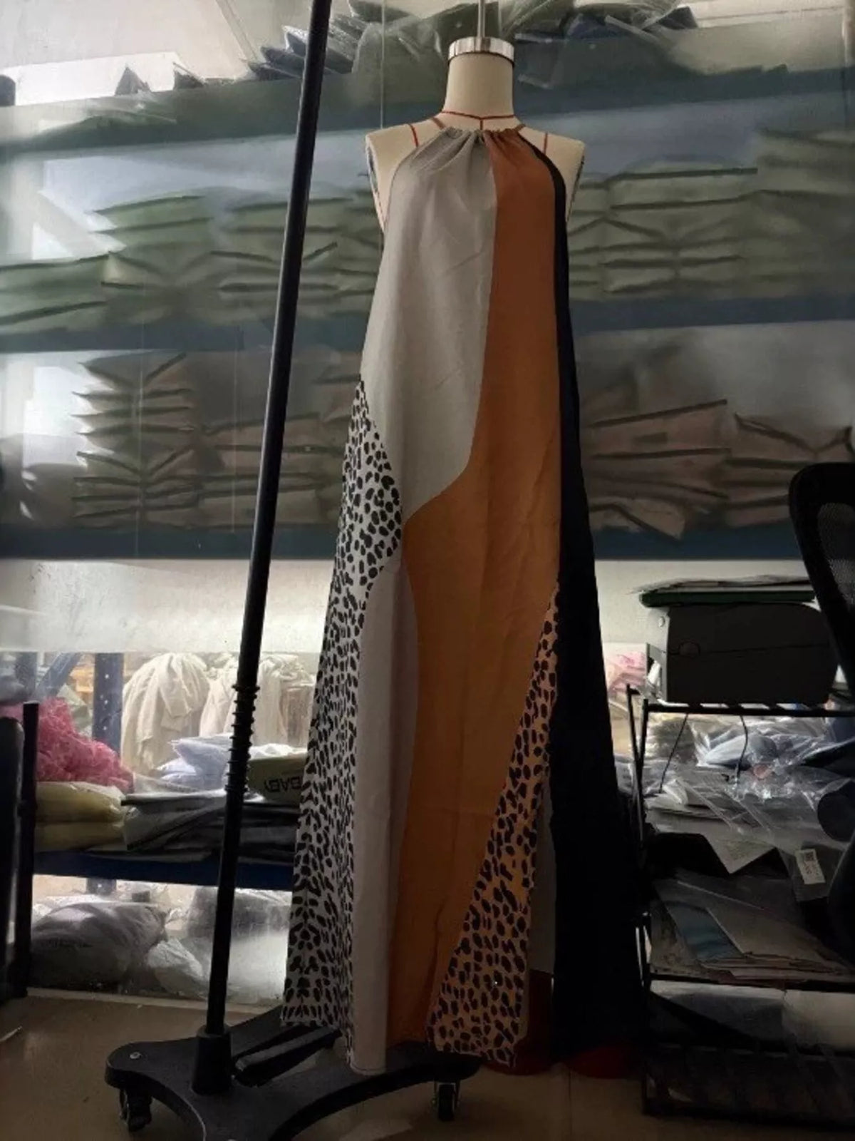 Sleeveless maxi dress on mannequin, color-block leopard print with draped panels