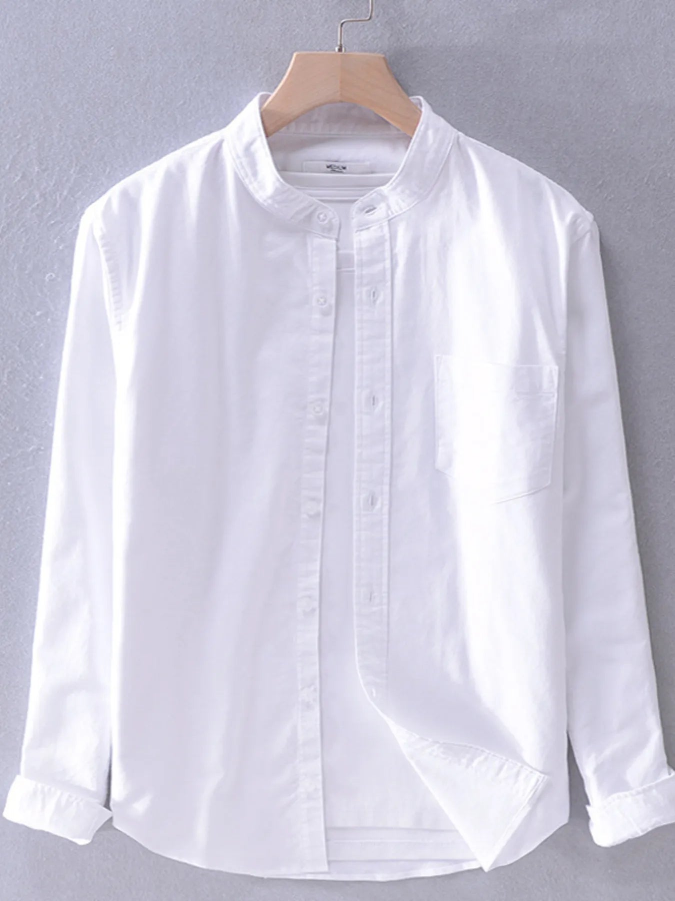 Long-sleeve button-up shirt in white with front buttons and chest pocket
