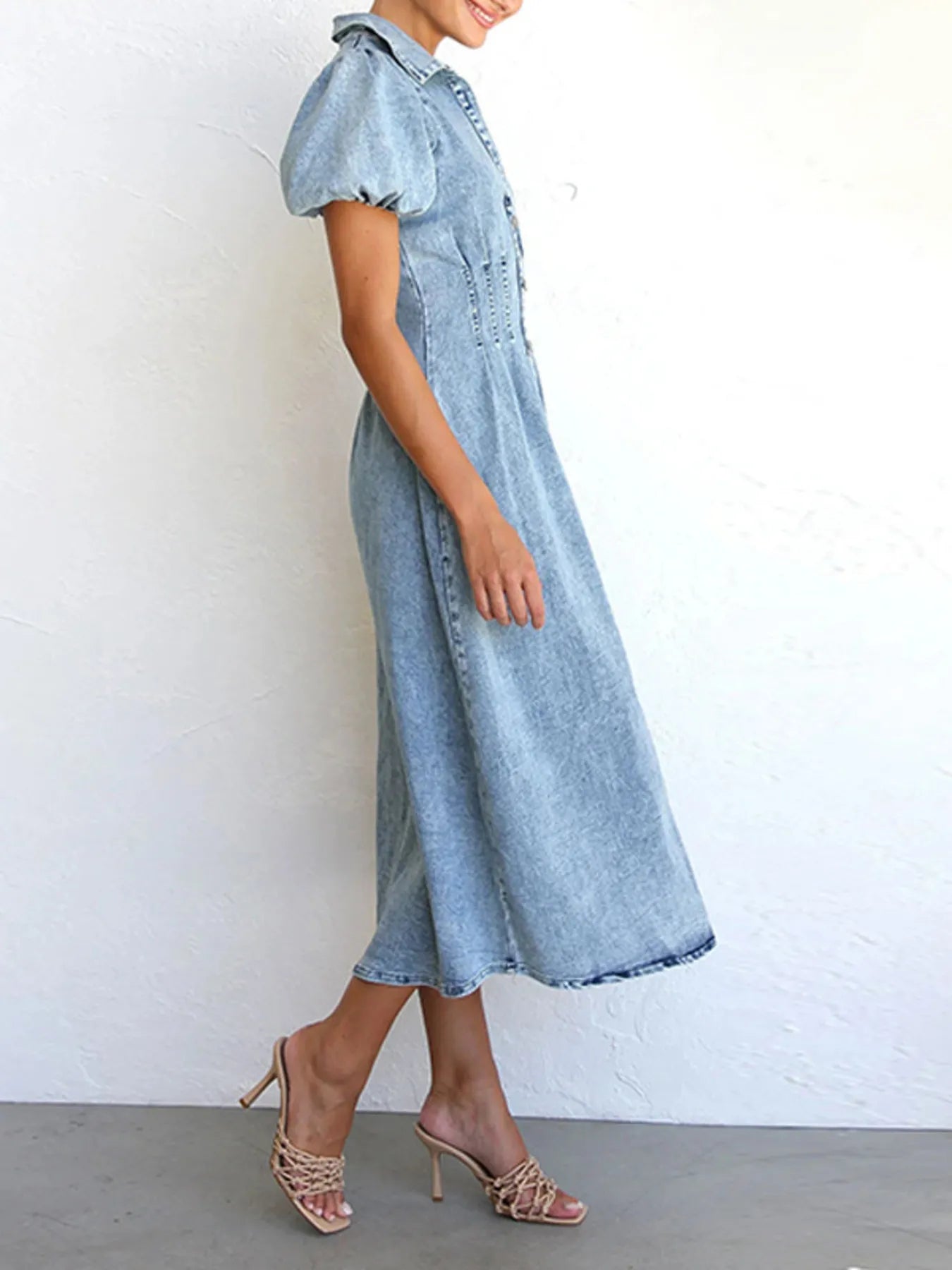 Blue denim midi dress with puff sleeves and button-front placket, side view
