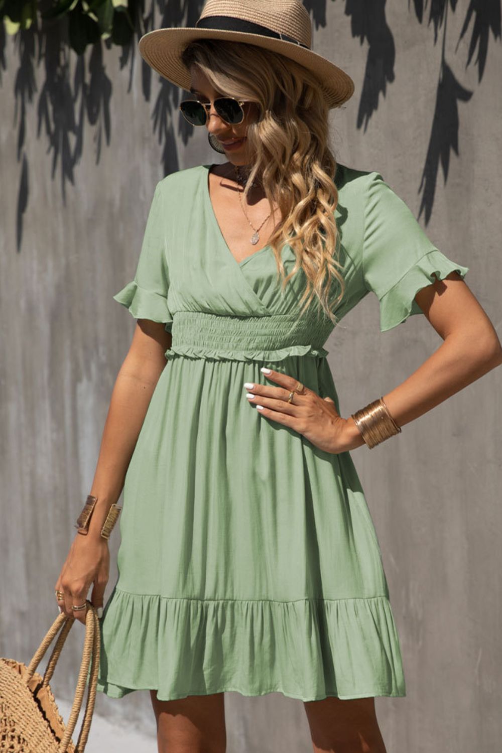 Light green smocked-waist V-neck dress with tiered ruffle hem and short flutter sleeves.