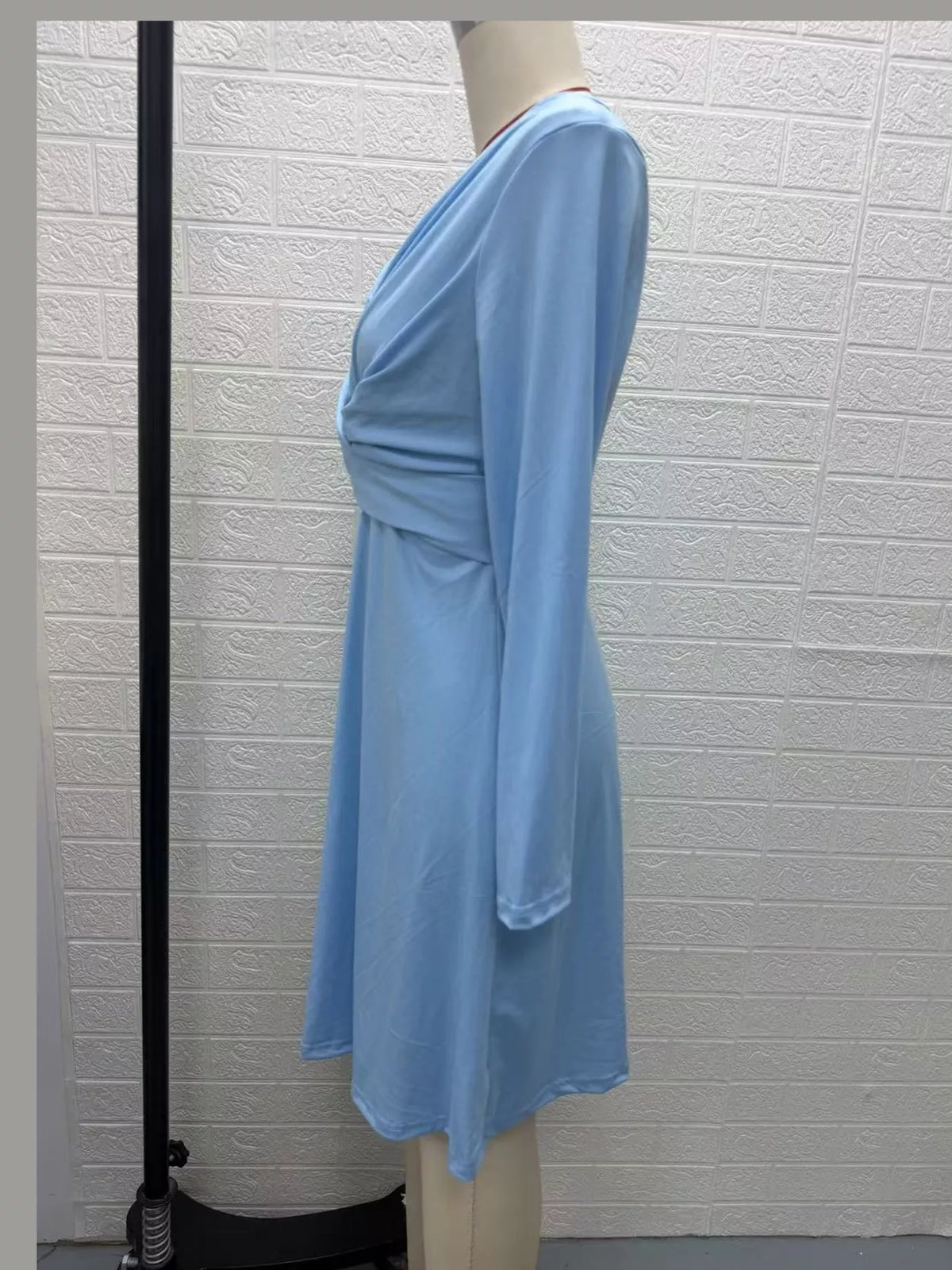 Light blue ruched midi dress with crisscross V-neck and long sleeves, side view