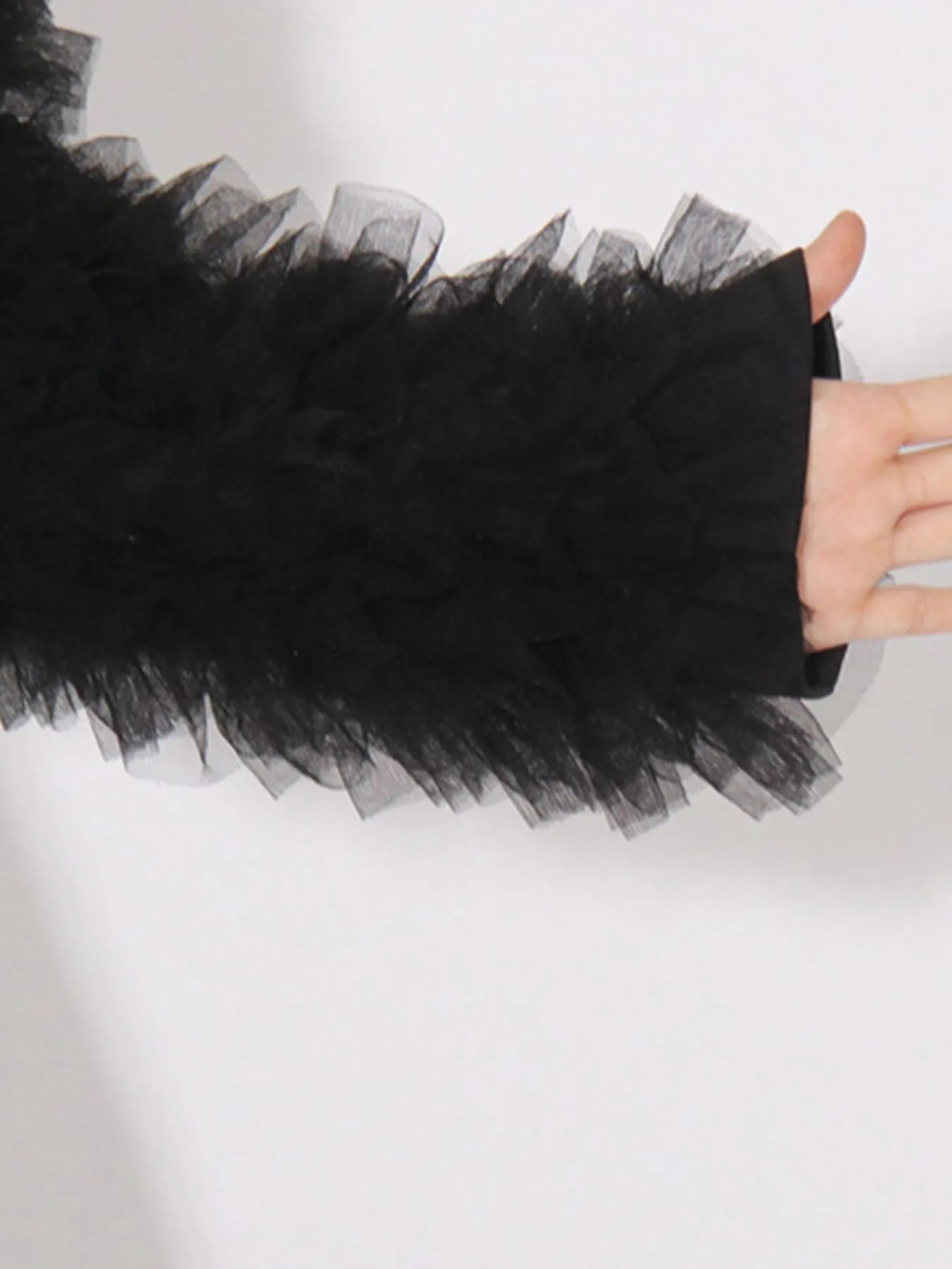 Black tulle sleeve trim close-up on long-sleeve blazer cuff