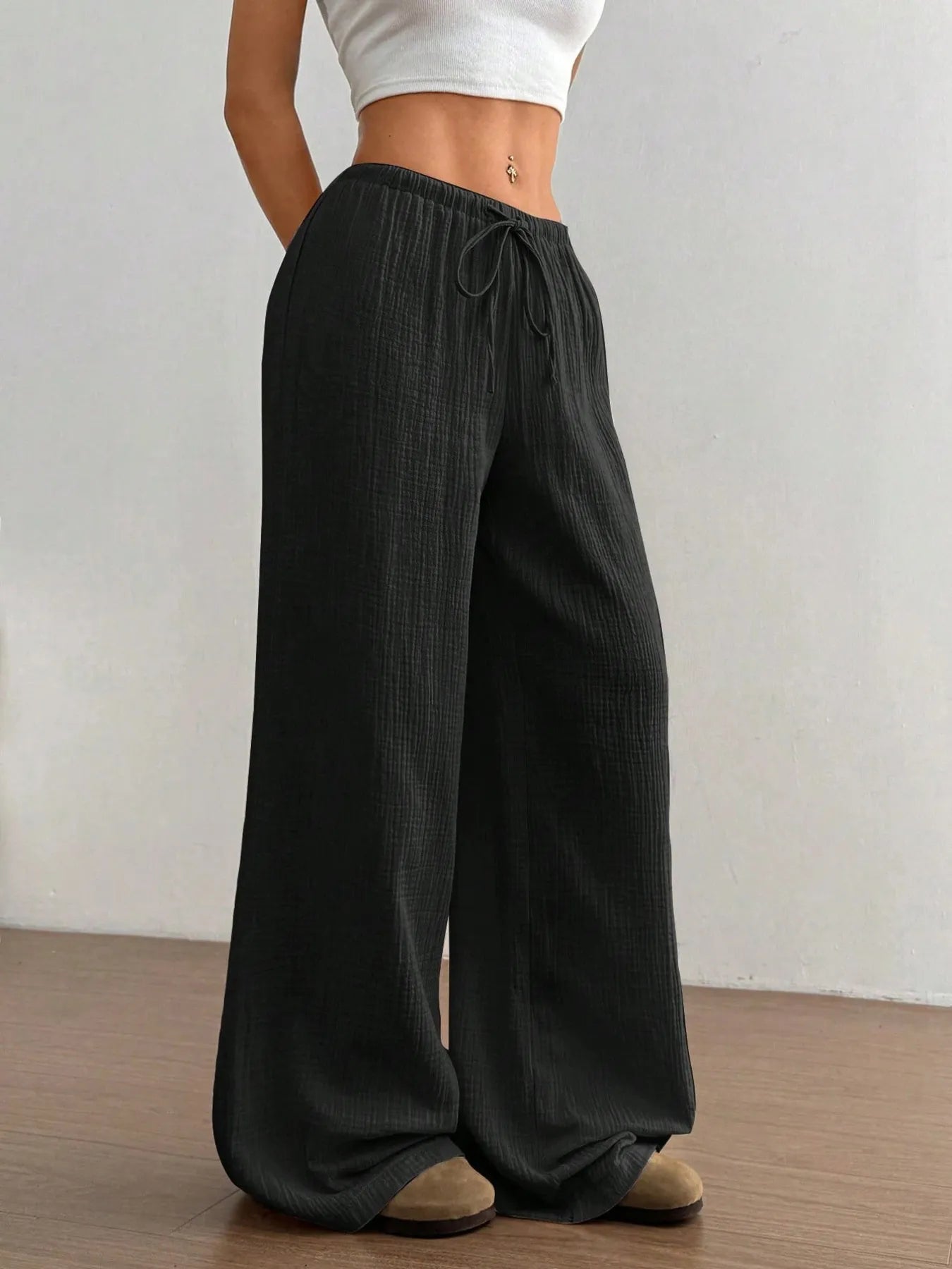 Black wide-leg drawstring pants with elastic waist and textured fabric