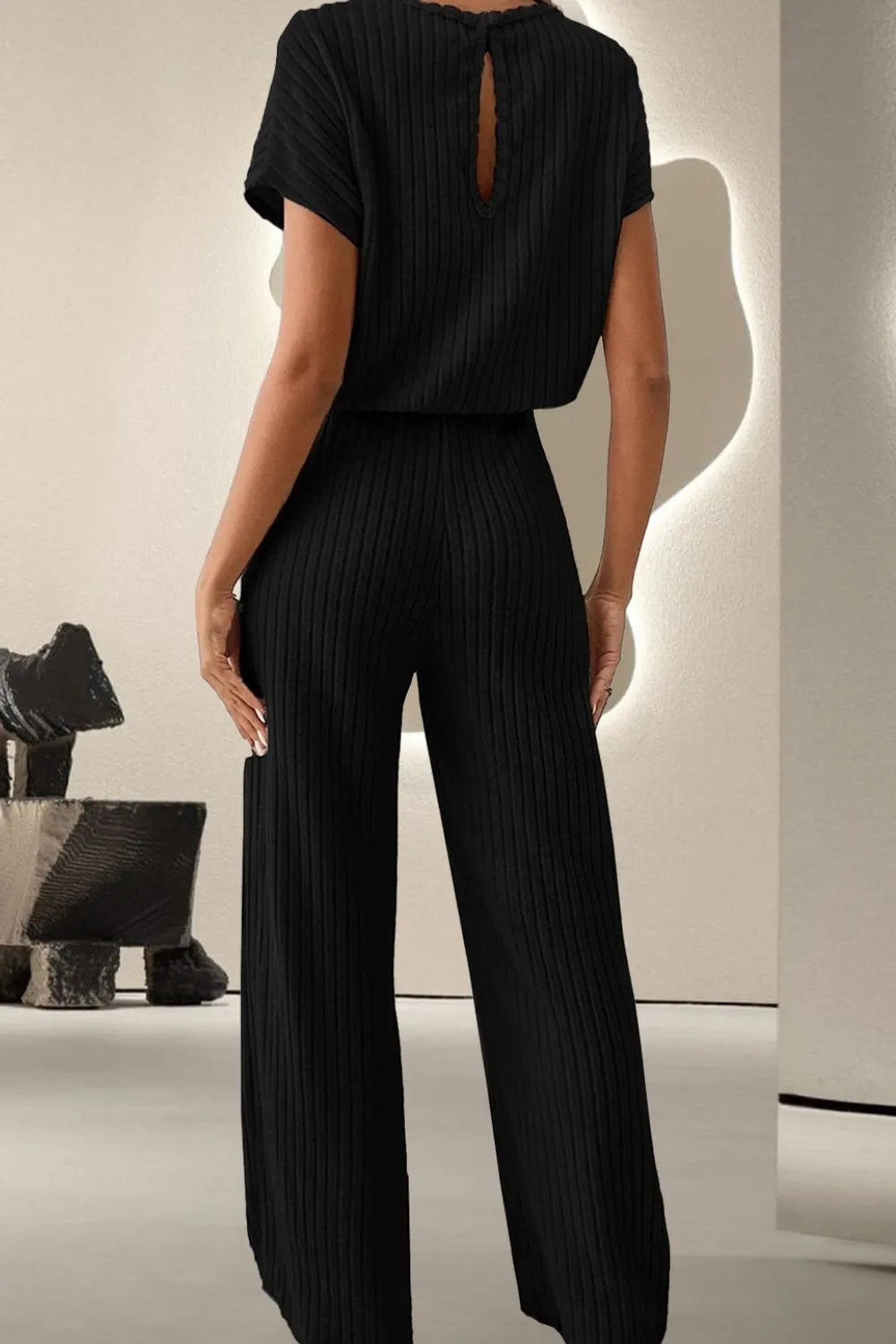 Black ribbed knit jumpsuit with open-back keyhole and wide legs