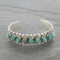 Open turquoise alloy bracelet with oval turquoise stones and silver bead detailing