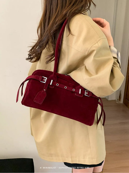 Red suede-look shoulder bag with buckle strap and side tassels