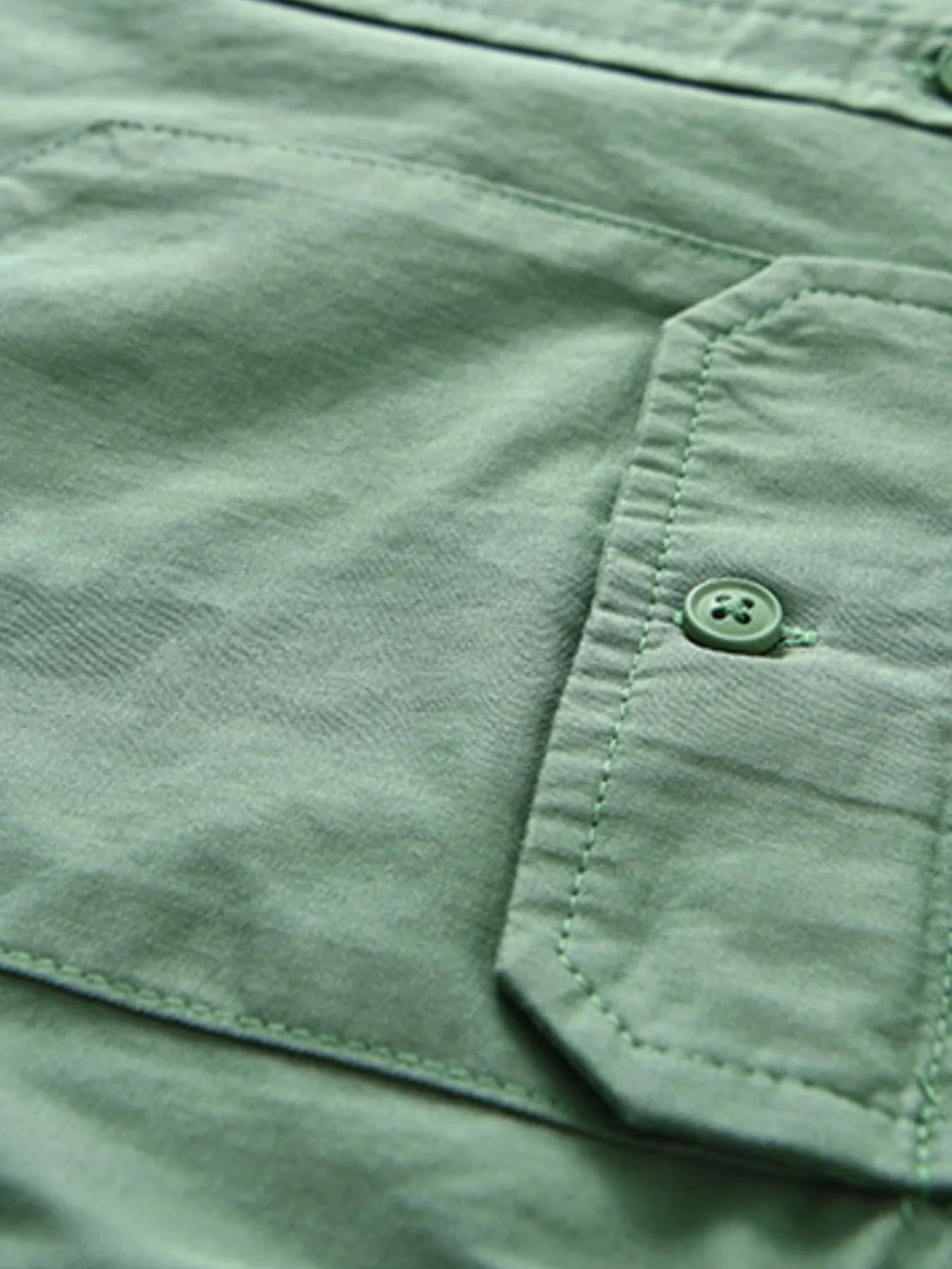 Green short-sleeve button-up shirt with chest pocket and button