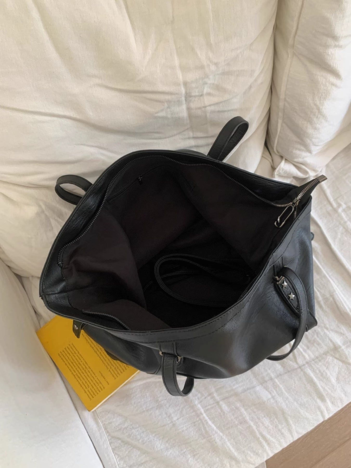 Star-embellished black PU leather shoulder bag, large size, open interior with zip top.