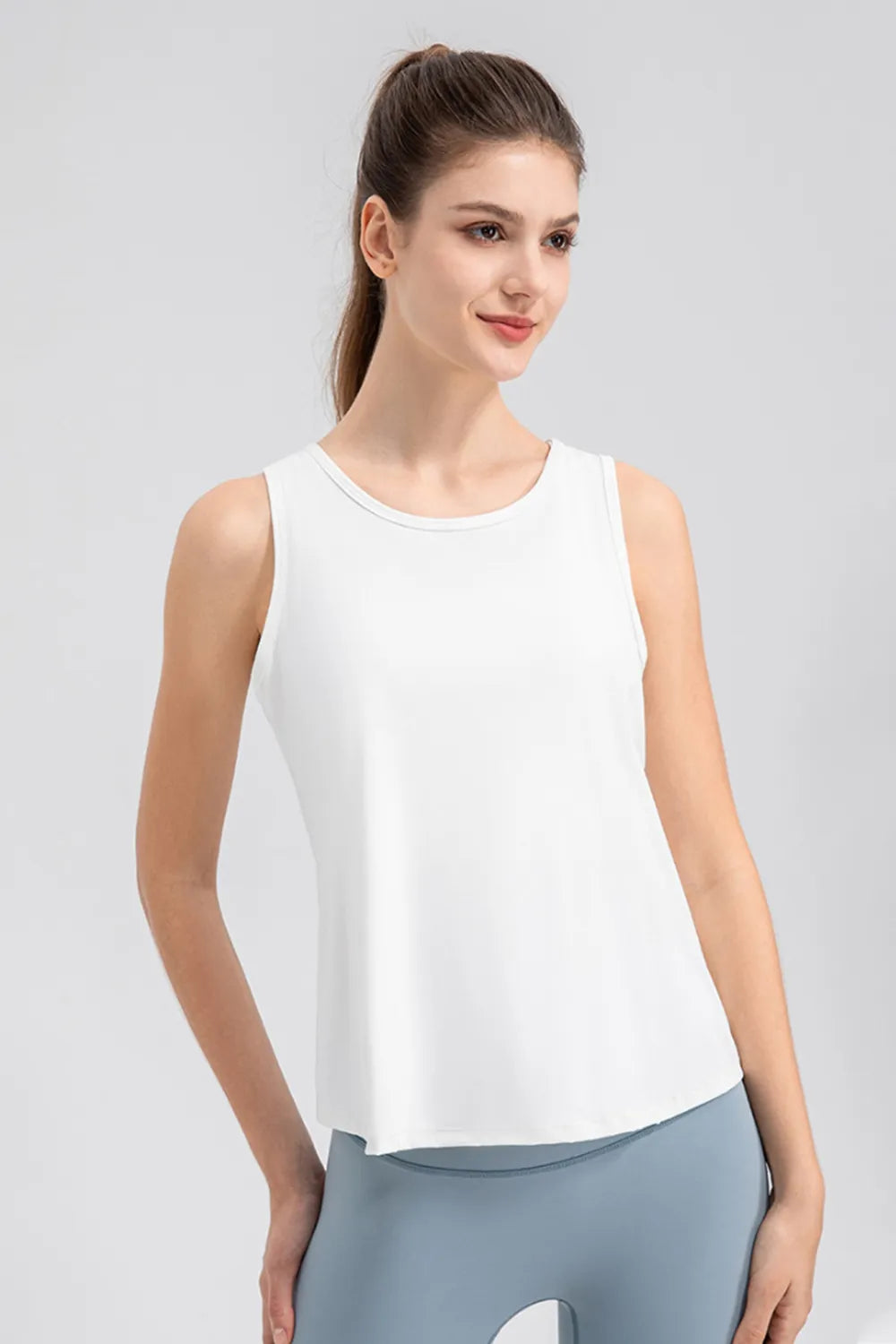 White active tank top with wide straps and round neckline, three-quarter view.