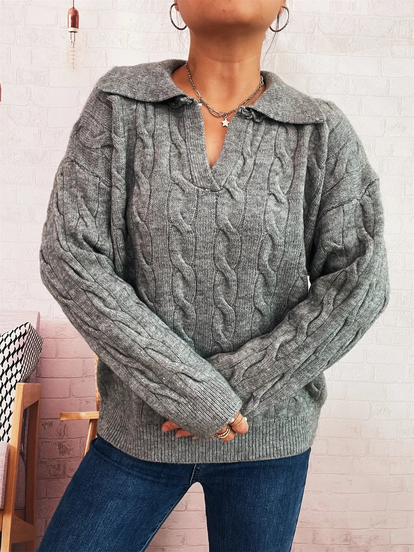 Gray cable-knit johnny-collar sweater with long sleeves, textured cables and V neckline.
