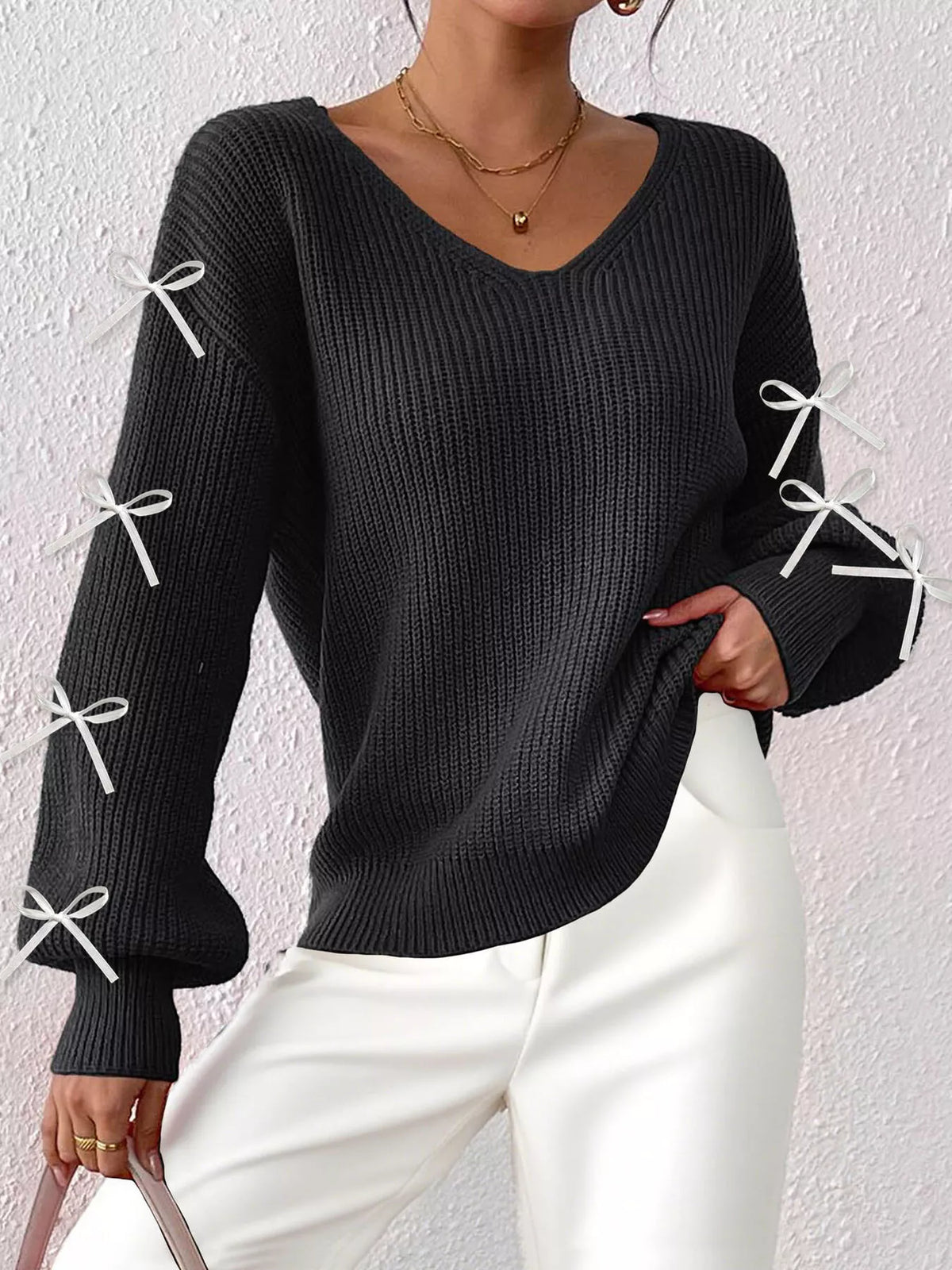 Lightweight knit V-neck sweater in black, with bow-tie cuff details and relaxed fit