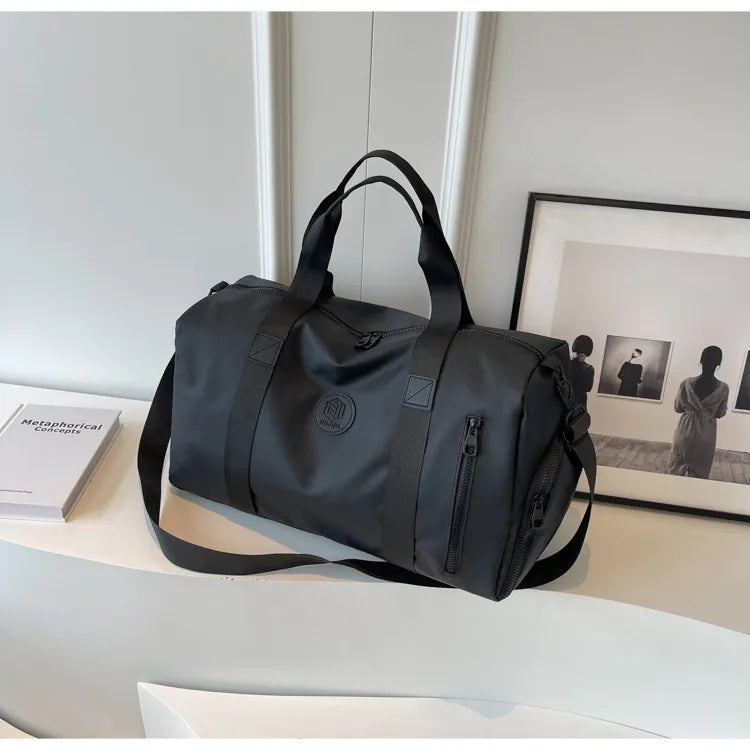 Dark gray large waterproof duffel bag with black shoulder strap and front zipper pocket