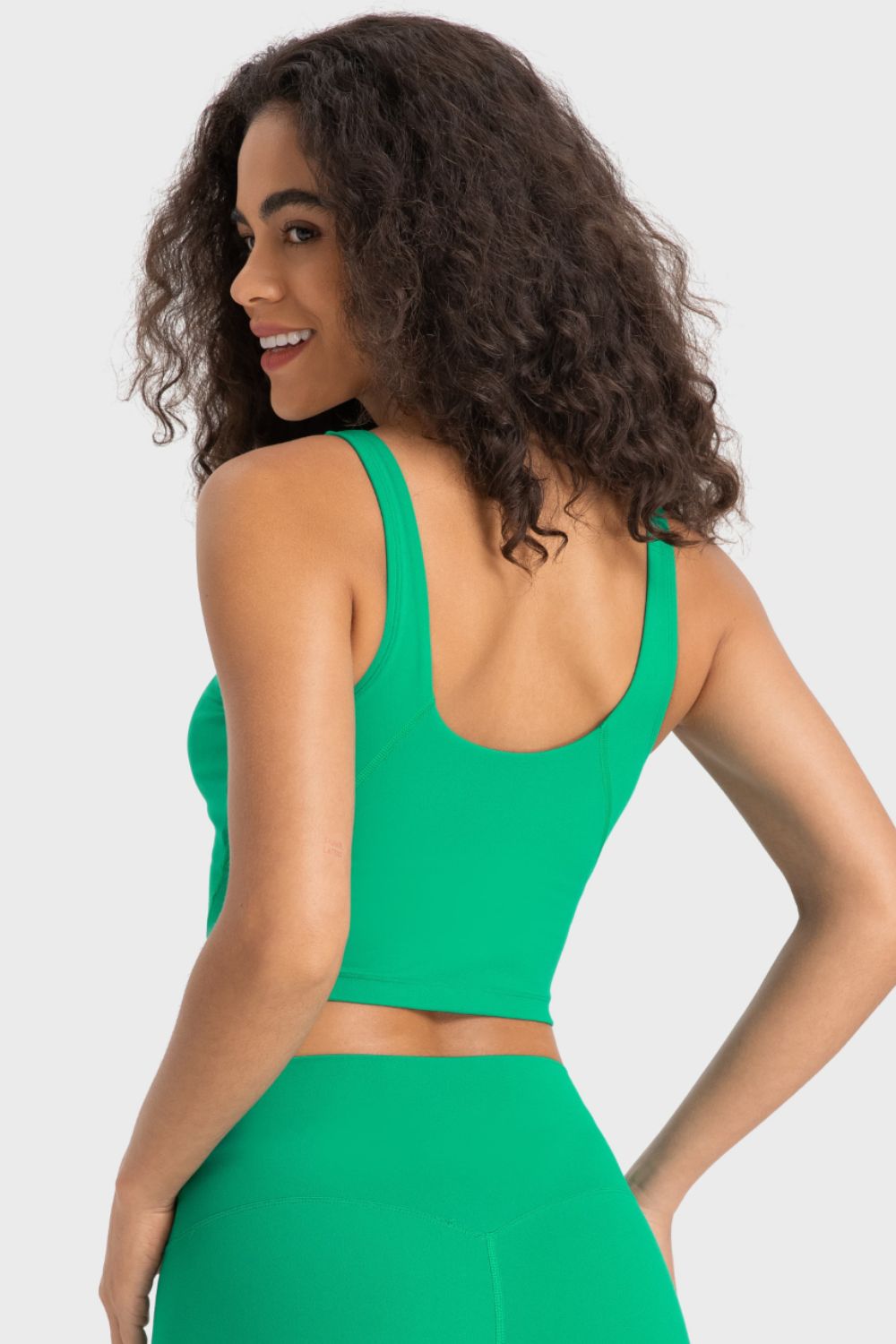 Deep V-neck crop sports bra, bright green color, back view from left side.