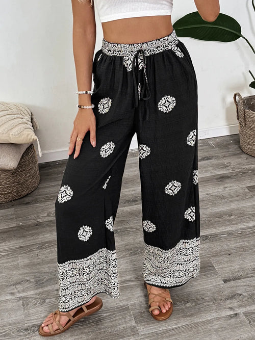Black wide-leg pants with boho medallion print, elastic drawstring waist, patterned hem