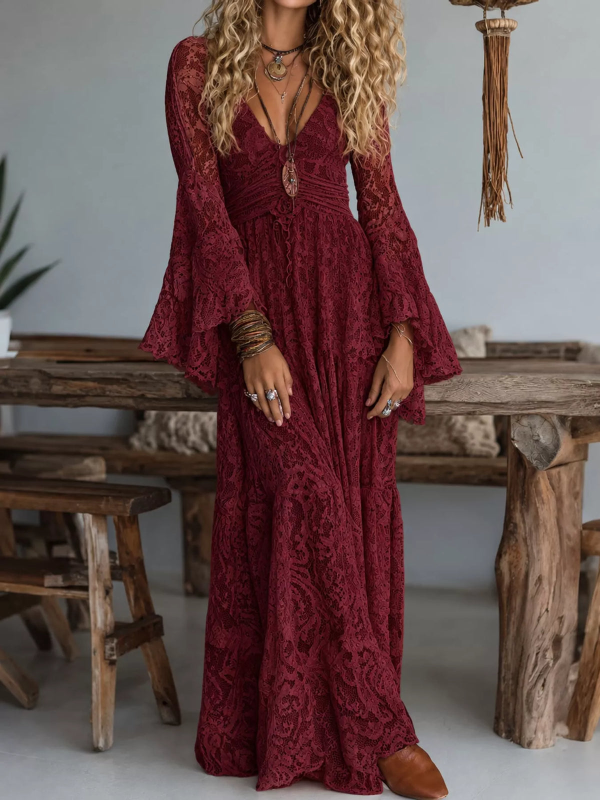 Burgundy lace maxi dress with ruched V-neck, button-front detail, and long flare sleeves.
