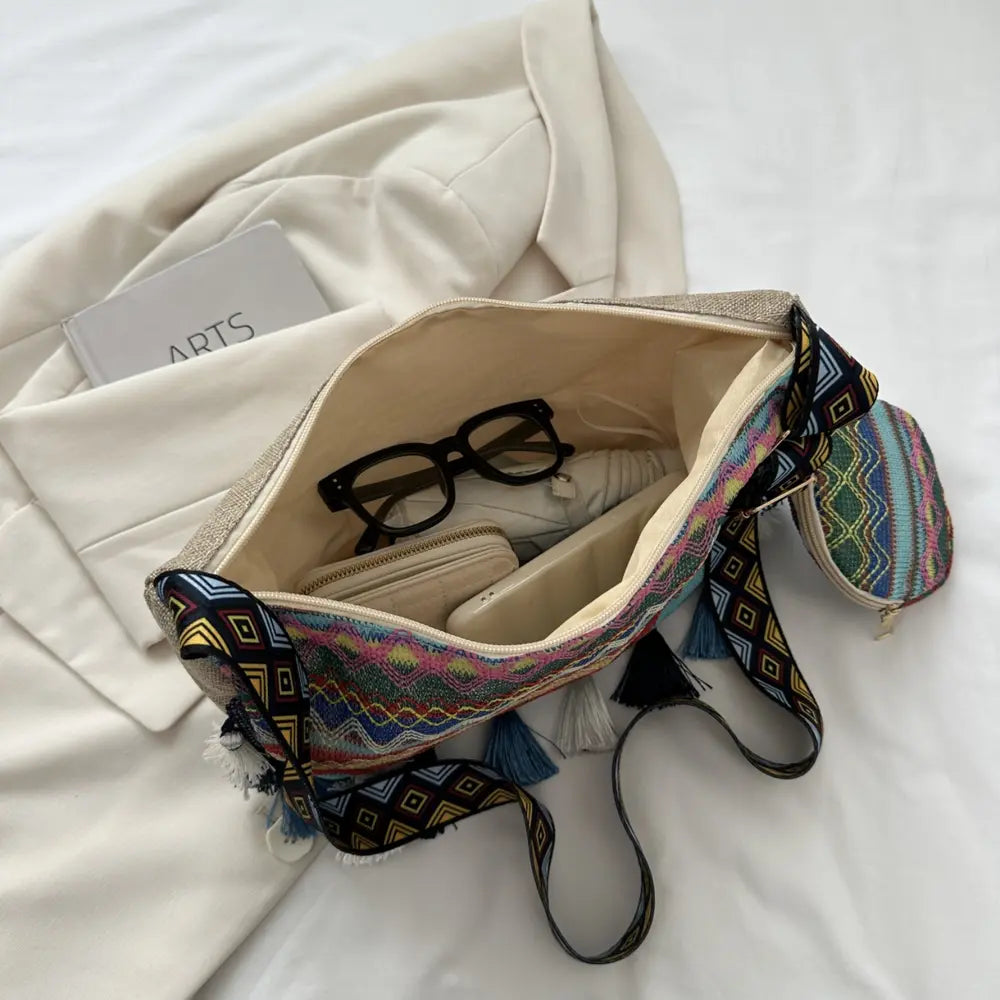 Printed crossbody bag interior with phone-sized pocket and drawstring cords.