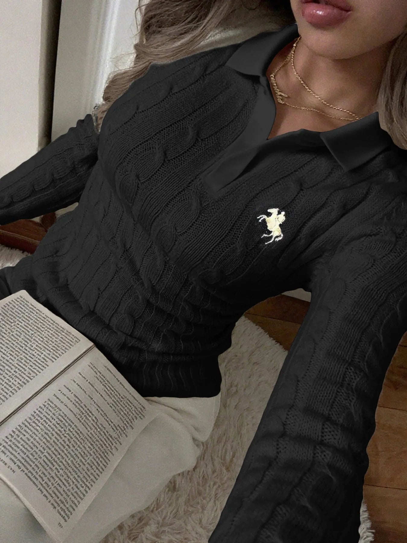 Black cable-knit long-sleeve sweater with textured cable pattern and small horse logo