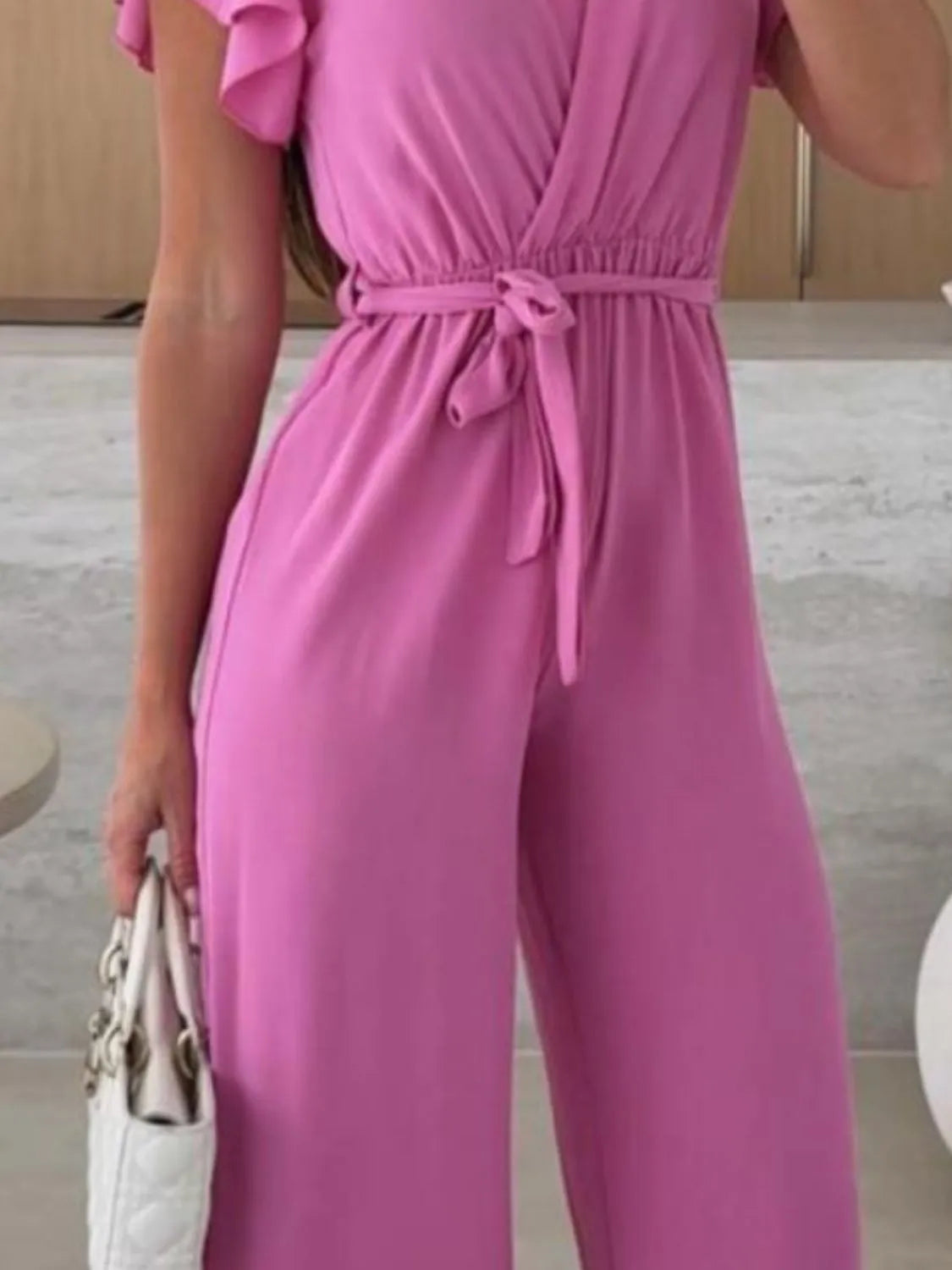 Fuchsia pink wide-leg jumpsuit with tied waist belt and surplice V-neck