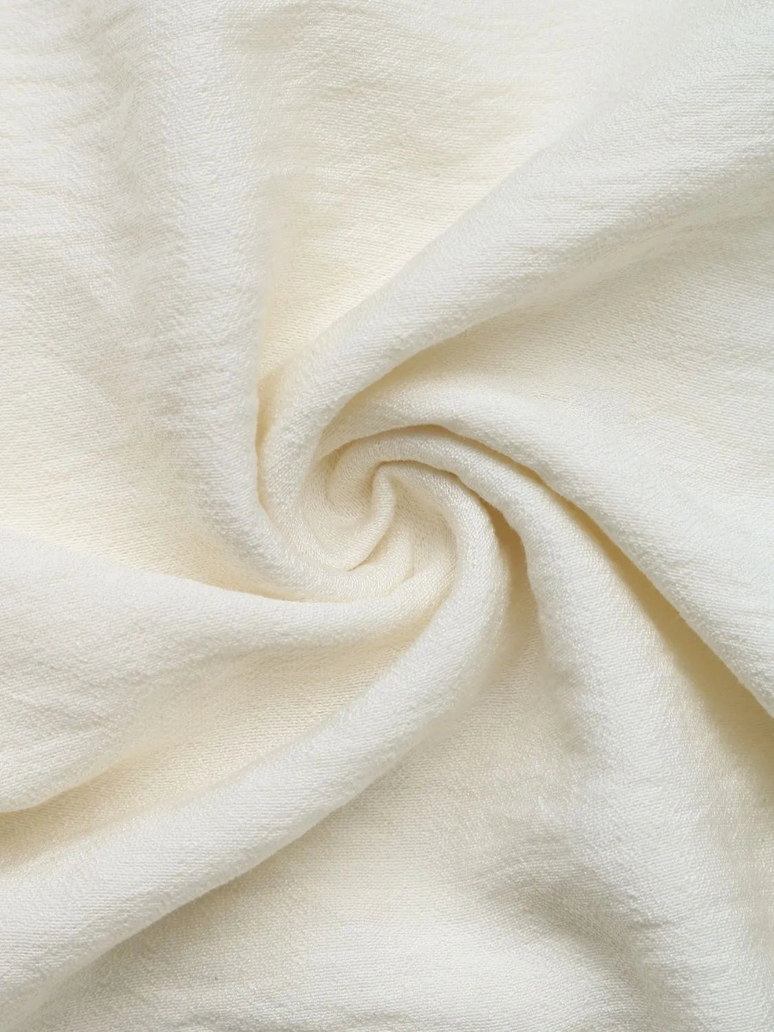 Cream textured fabric for wide-leg pants, folded close-up