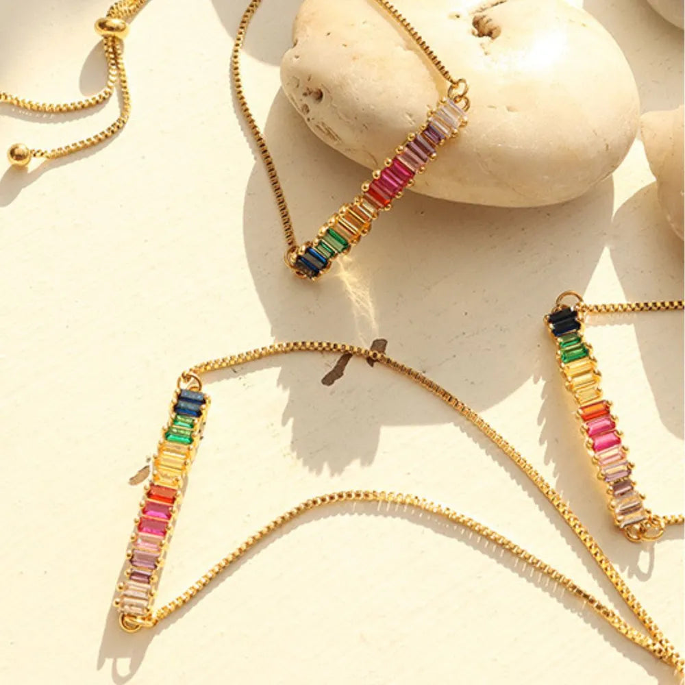 Gold-tone multicolor zircon bracelets laid flat with gemstone bar details
